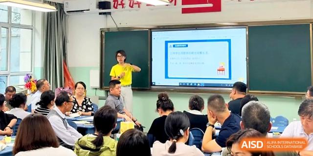 A teacher in a yellow shirt stands at the front of a classroom during a lesson with students at Urumqi Bayi High School.