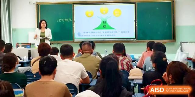 Parents attend a seminar or meeting featuring a presentation about student development at Urumqi Bayi High School.