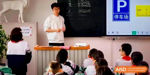 A young male student stands in front of his peers to present a topic in a classroom at Urumqi Bayi High School.