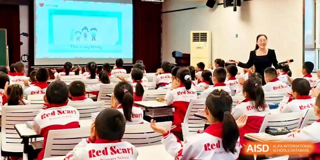 Students sit at their desks and watch a presentation on a large screen during an assembly or lecture at Urumqi Bayi High School.