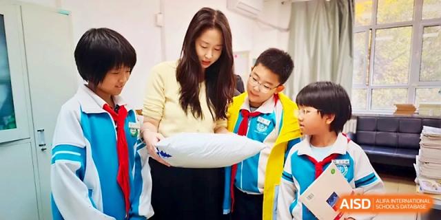 A teacher leans over a desk to provide one-on-one guidance to a student during a class at Urumqi Bayi High School.