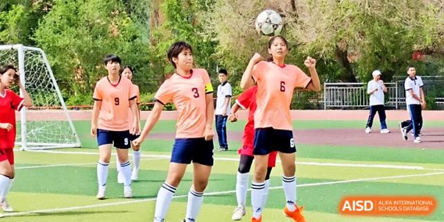 A student jumps to head a soccer ball during a practice session on the athletic field at Urumqi Bayi High School.