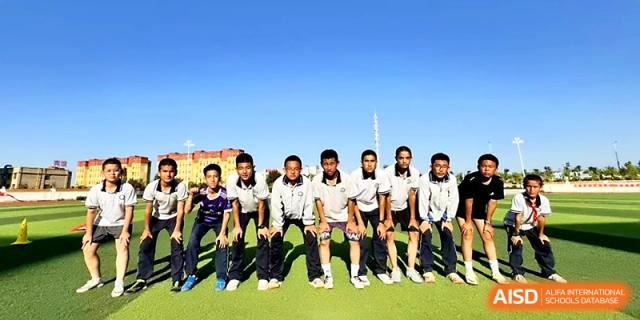 A group of boys in matching athletic gear poses for a team photo on the sunny outdoor court at Urumqi Bayi High School.