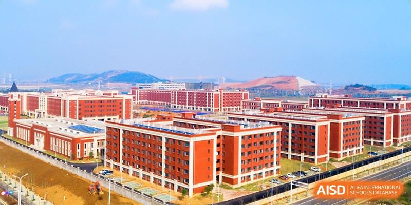 An aerial view shows the expansive campus of red brick buildings and modern facilities at Wuhan Guanggu Future School.