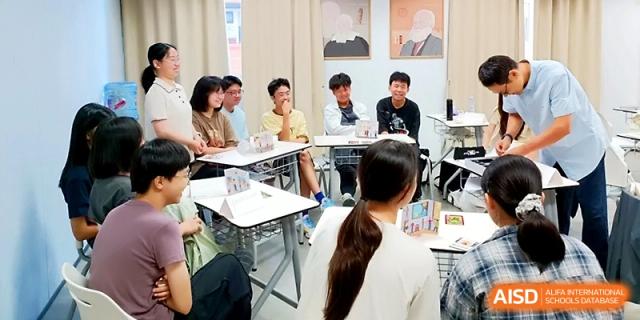 Students and teachers sit in a circular arrangement for an open, collaborative group discussion in a bright room at Wuhan Guanggu Future School.