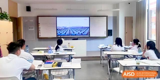 An empty classroom shows a bright digital screen at the front, with organized desks and chairs at Wuhan Guanggu Future School.