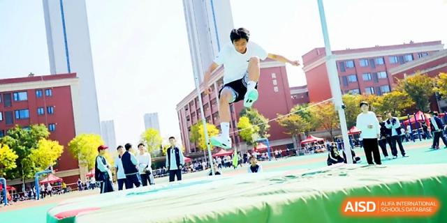 A student athlete successfully clears a high jump bar during a track and field competition at Wuhan Guanggu Future School.