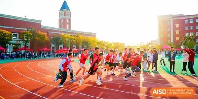 A group of students in red jerseys sprint at the start of a race on the running track at Wuhan Guanggu Future School.