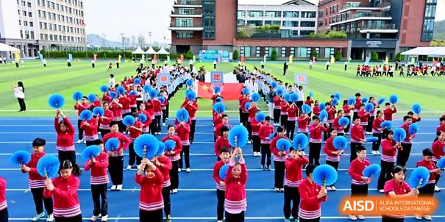 Rows of students in red and blue uniforms participate in a massive outdoor formation drill at Yung Wing School Zhuhai.