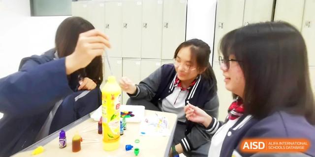 A group of students works collaboratively, using a dropper and a yellow bottle to conduct a colorful liquid experiment at Zhangjiagang Foreign Language School.