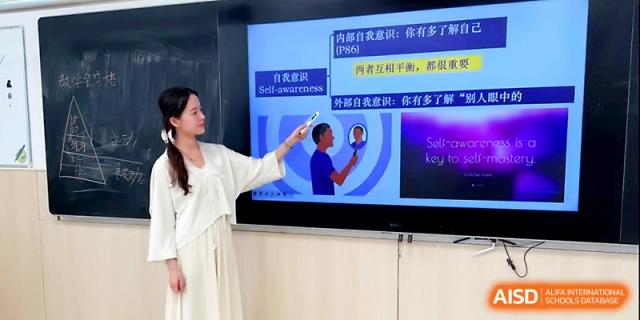 A teacher uses a pointer to highlight specific text on a digital screen during a lecture at Zhangjiagang Foreign Language School.