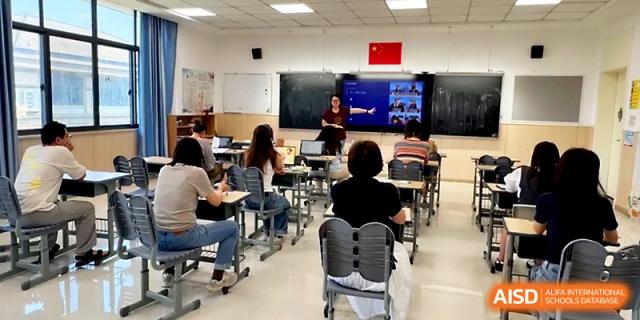 Students sit at their desks facing the front of the room during a presentation in a modern classroom at Zhangjiagang Foreign Language School.