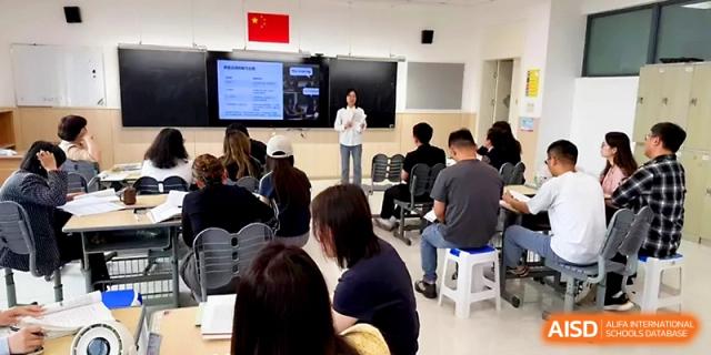 An educator stands at the front of a classroom during a multimedia lesson for a group of students at Zhangjiagang Foreign Language School.