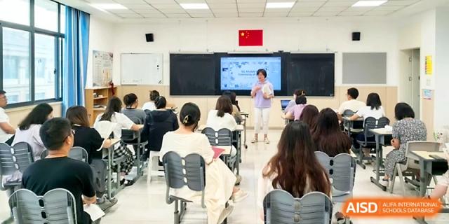 A classroom of students listens to a teacher presenting information on a digital screen at Zhangjiagang Foreign Language School.