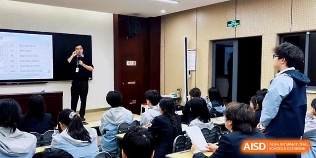 Students sit in a lecture hall setting, listening to a speaker during a school-wide presentation at Zhangjiagang Foreign Language School.