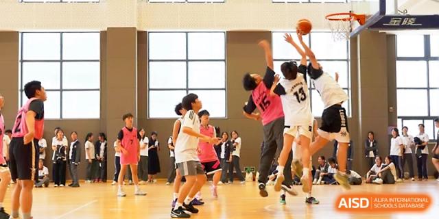 Student athletes jump high to compete for a rebound under the basket during a basketball tournament at Zhangjiagang Foreign Language School.
