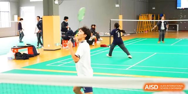 A student athlete looks up toward the shuttlecock during a fast-paced badminton match at Zhangjiagang Foreign Language School.