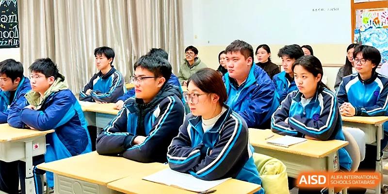 Attentive students in blue track jackets sit at their desks, focusing on a lesson during a classroom session at Zhengzhou No.19 High School.