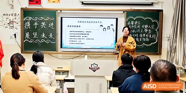 A female teacher leads a presentation using a digital whiteboard to explain concepts to her students at Zhengzhou No.19 High School.