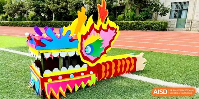 A close-up view of a vibrant, multi-colored dragon head decoration handcrafted by students at Zhengzhou No.19 High School.
