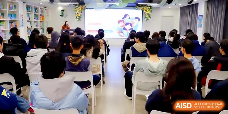 A group of students sitting in chairs and watching a presentation on a large screen at Beijing Financial Street Runze School