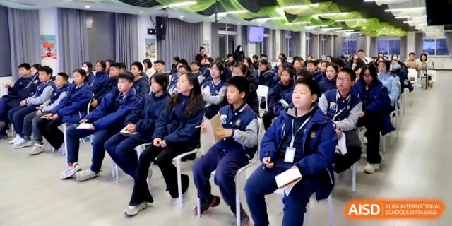 Rows of students in blue uniforms sitting and listening attentively during a school assembly at Beijing Financial Street Runze School