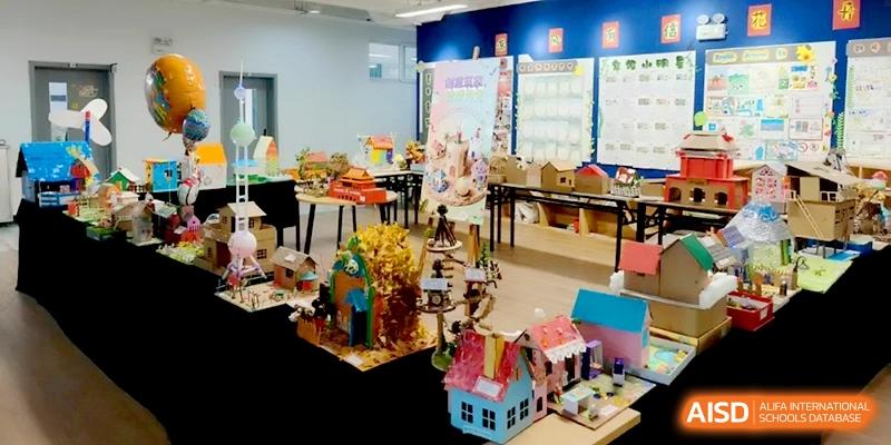 An indoor display of colorful handmade house models and student craft projects at Beijing Financial Street Runze School