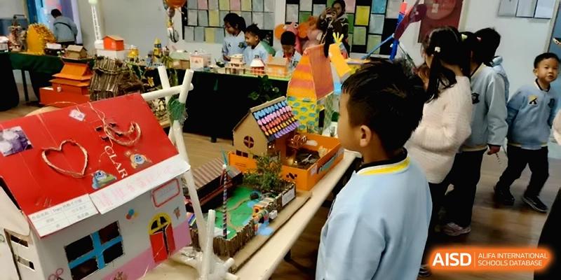 A young student looking at detailed architectural models created for a school project at Beijing Financial Street Runze School