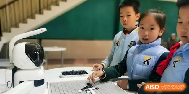 A young student in a blue school uniform focuses intently while placing black and white stones during a game of Go at Beijing Financial Street Runze School.