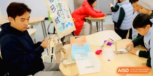 Students work on engineering models and mechanical wooden kits during a classroom activity in a bright learning space at Beijing Financial Street Runze School.