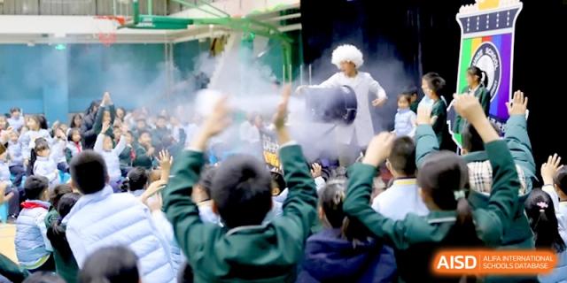 A science demonstration using fog and vapor entertains a group of students at Beijing Financial Street Runze School.
