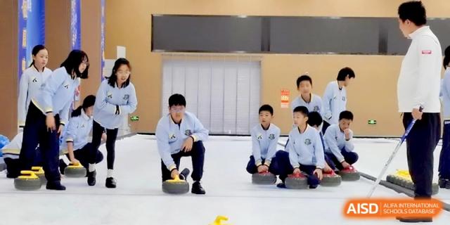 Students practicing floor curling on an indoor rink during a physical education class at Beijing Financial Street Runze School.