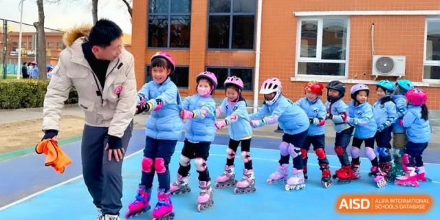 A group of young children in helmets and pads enjoy a roller skating lesson at Beijing Financial Street Runze School.
