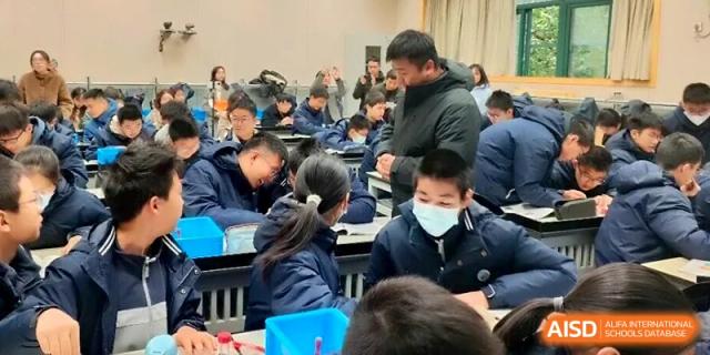 A group of students in blue winter jackets engages in a collaborative group discussion during a classroom lesson at Changzhou Senior High School of Jiangsu Province.