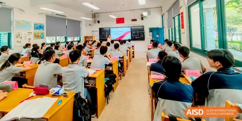 A wide-angle view of a bright classroom filled with students in grey uniforms during a morning lecture at Changzhou Senior High School of Jiangsu Province.