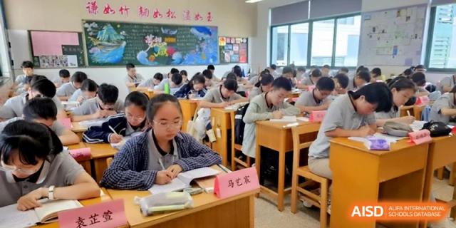 Students focused on their studies at individual wooden desks in a bright, organized classroom at Changzhou Senior High School of Jiangsu Province.