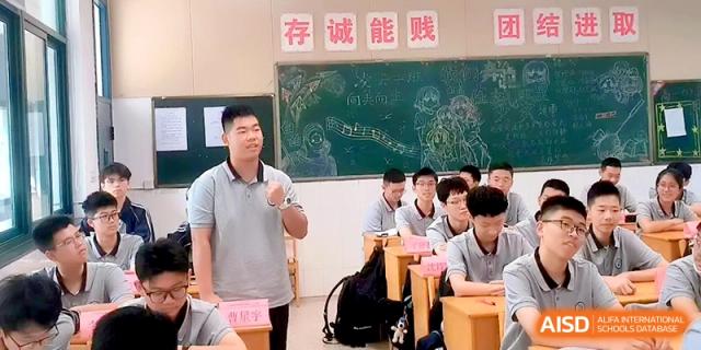 A male student stands at his desk to answer a question during a classroom discussion at Changzhou Senior High School of Jiangsu Province.