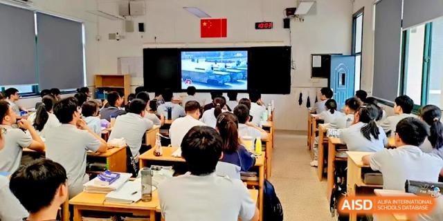 Students seated in a dark lecture hall watch a presentation on a large digital projection screen at Changzhou Senior High School of Jiangsu Province.