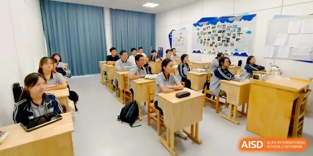 A group of students in a bright, clean classroom listen to a teacher's lecture at Changzhou Senior High School of Jiangsu Province.