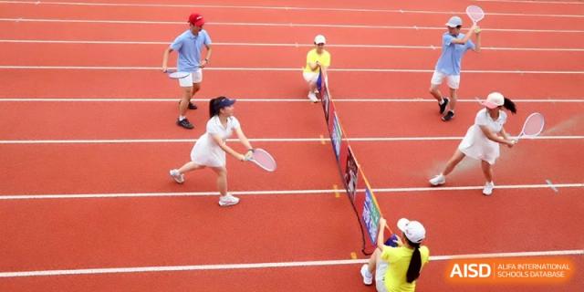 Two students play an energetic game of tennis on an outdoor court during a sports competition at Changzhou Senior High School of Jiangsu Province.
