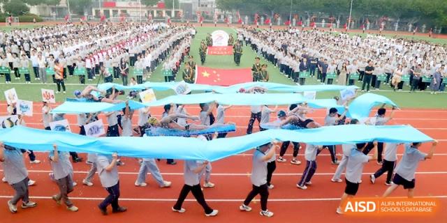 Students work together to carry a massive blue banner across the sports field during an event at Changzhou Senior High School of Jiangsu Province.