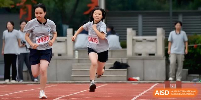 A young female student sprints down the red athletic track during a competitive running event at Changzhou Senior High School of Jiangsu Province.