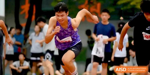 A male student in a purple jersey displays intense focus while sprinting during a track meet at Changzhou Senior High School of Jiangsu Province.