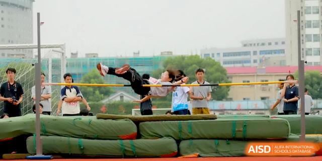 A student athlete mid-leap while attempting to clear the bar during a high jump competition at Changzhou Senior High School of Jiangsu Province.