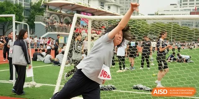 A female student leans back to gain momentum before a shot put throw on the sports field at Changzhou Senior High School of Jiangsu Province.