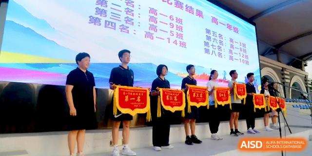 Students and staff stand in a line holding red award banners for their sports achievements at Changzhou Senior High School of Jiangsu Province.