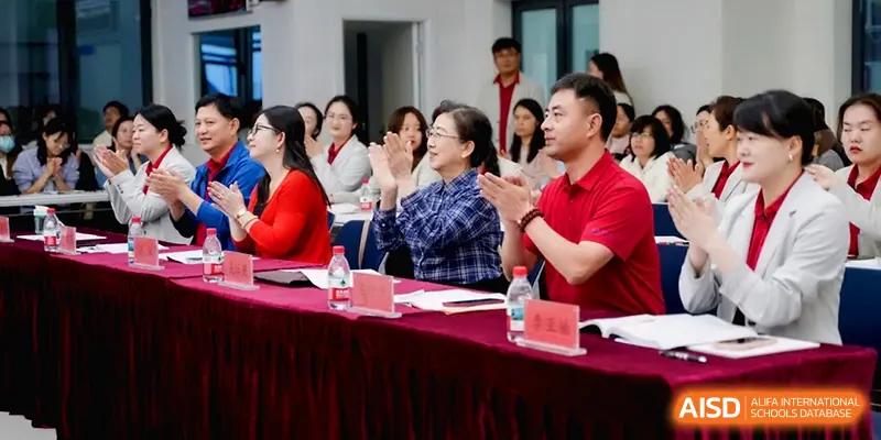 A panel of faculty members applauds during a formal ceremony or presentation held at the Beijing Haidian Foreign Language Shi Yan School Hainan Campus.