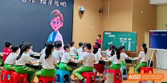Young students sit on stools during an interactive science or creative lesson at the Beijing Haidian Foreign Language Shi Yan School Hainan Campus.