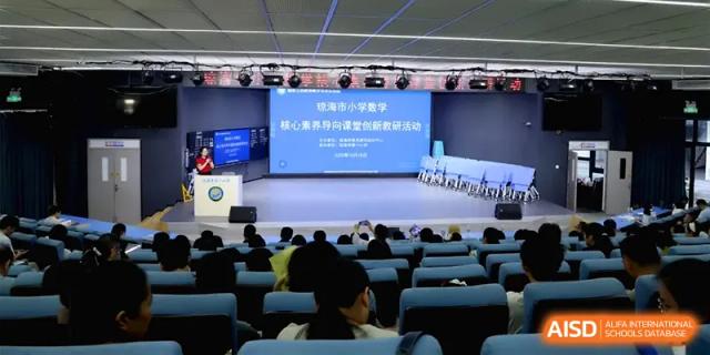 A wide view of a large lecture hall filled with students during a formal school presentation at Beijing Haidian Foreign Language Shi Yan School Hainan Campus.