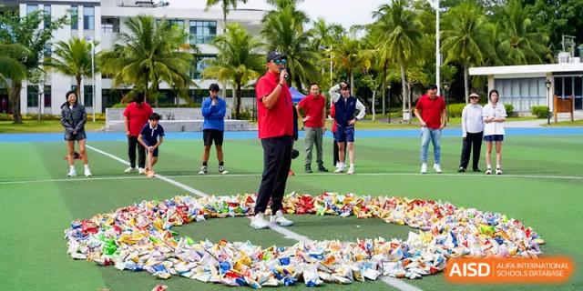 An instructor in a red shirt stands in a circle of colorful markers during a physical education class at Beijing Haidian Foreign Language Shi Yan School Hainan Campus.